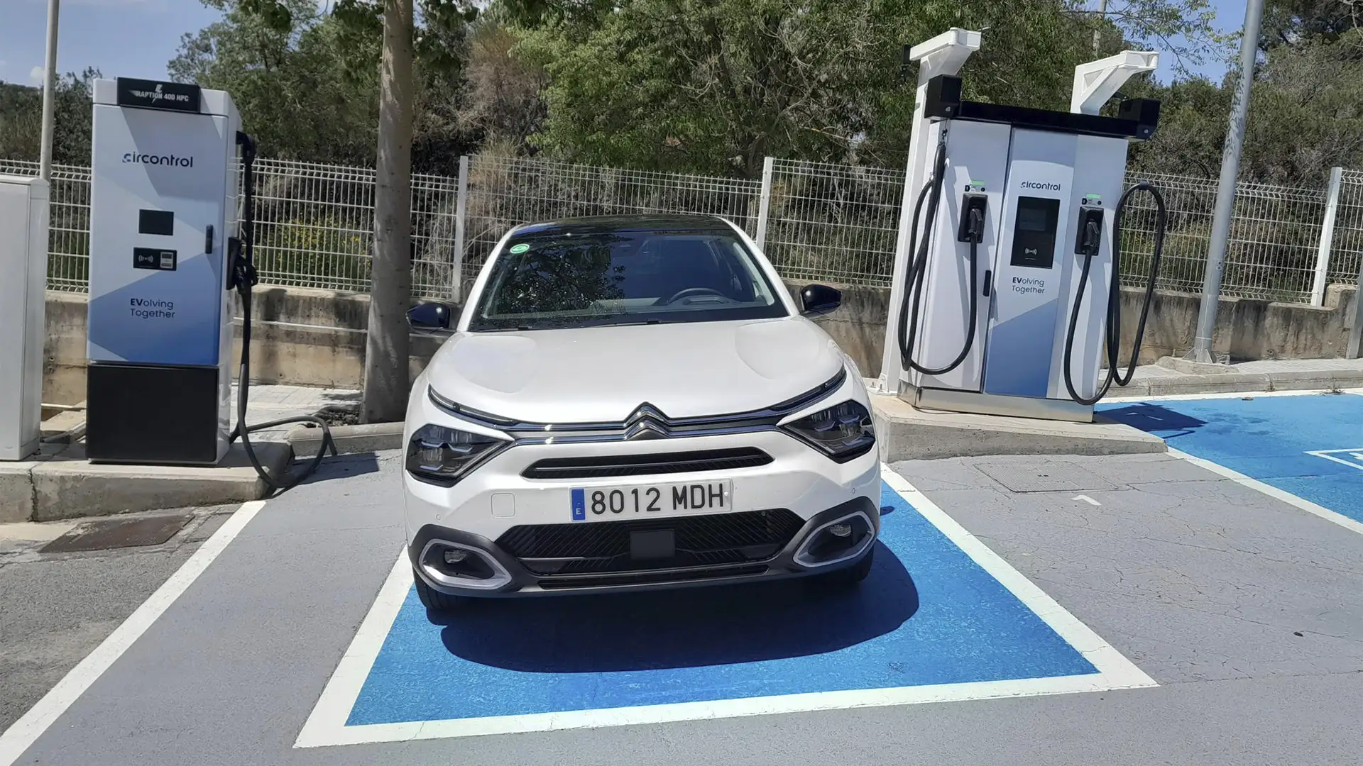 Vehículo eléctrico Citroën ë-C4 X estacionado durante un proceso de recarga.