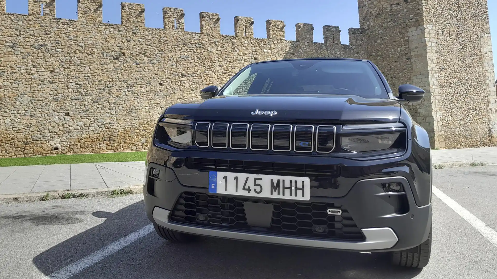 Vehículo eléctrico Jeep Avenger cargando su batería en una toma de corriente.