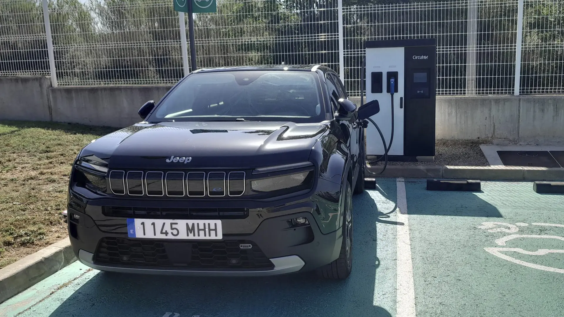 Vehículo eléctrico Jeep Avenger estacionado junto a un punto de carga de Circutor.