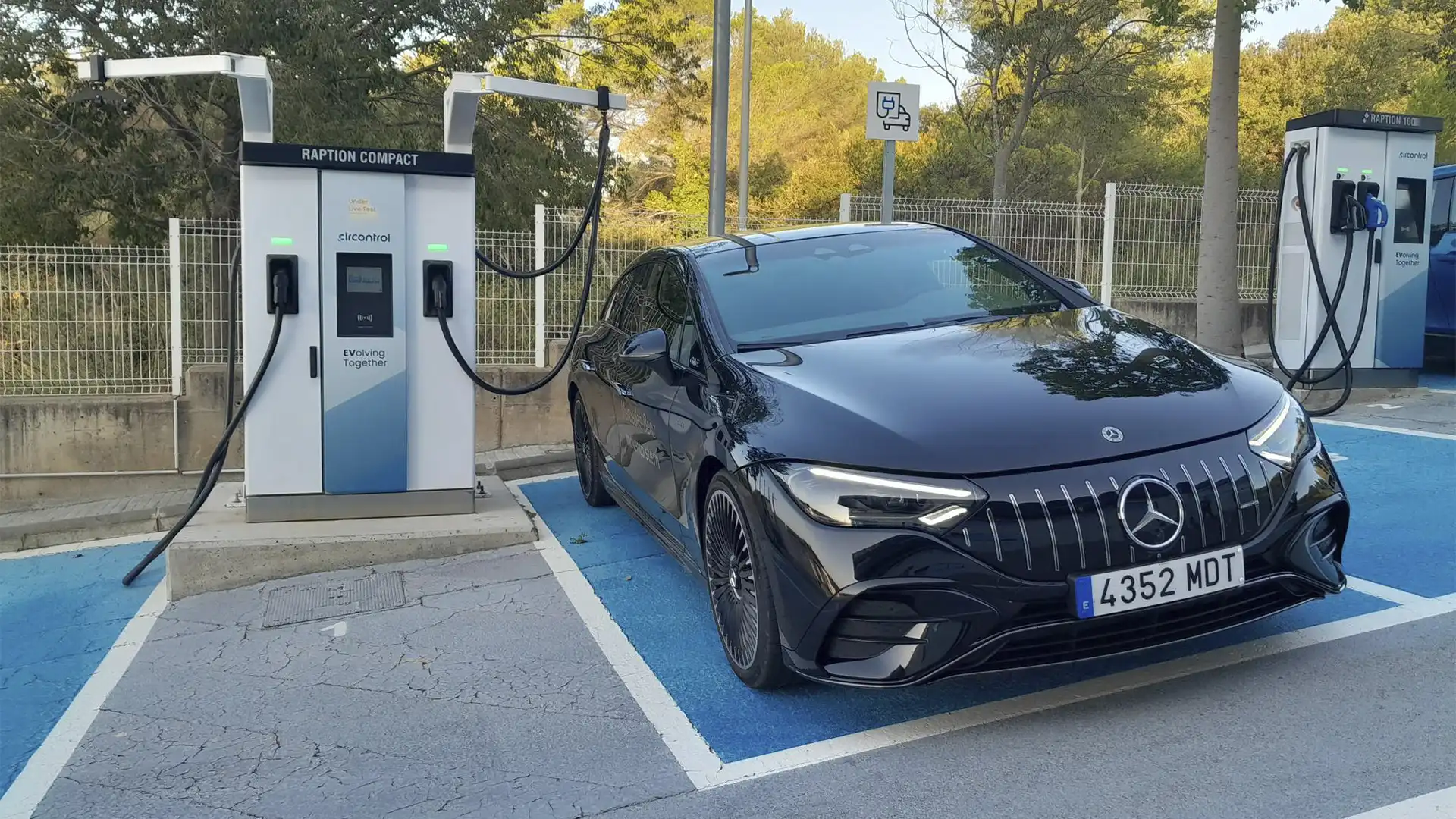 Vehículo eléctrico Mercedes-Benz EQE AMG cargando su batería en una estación de recarga.