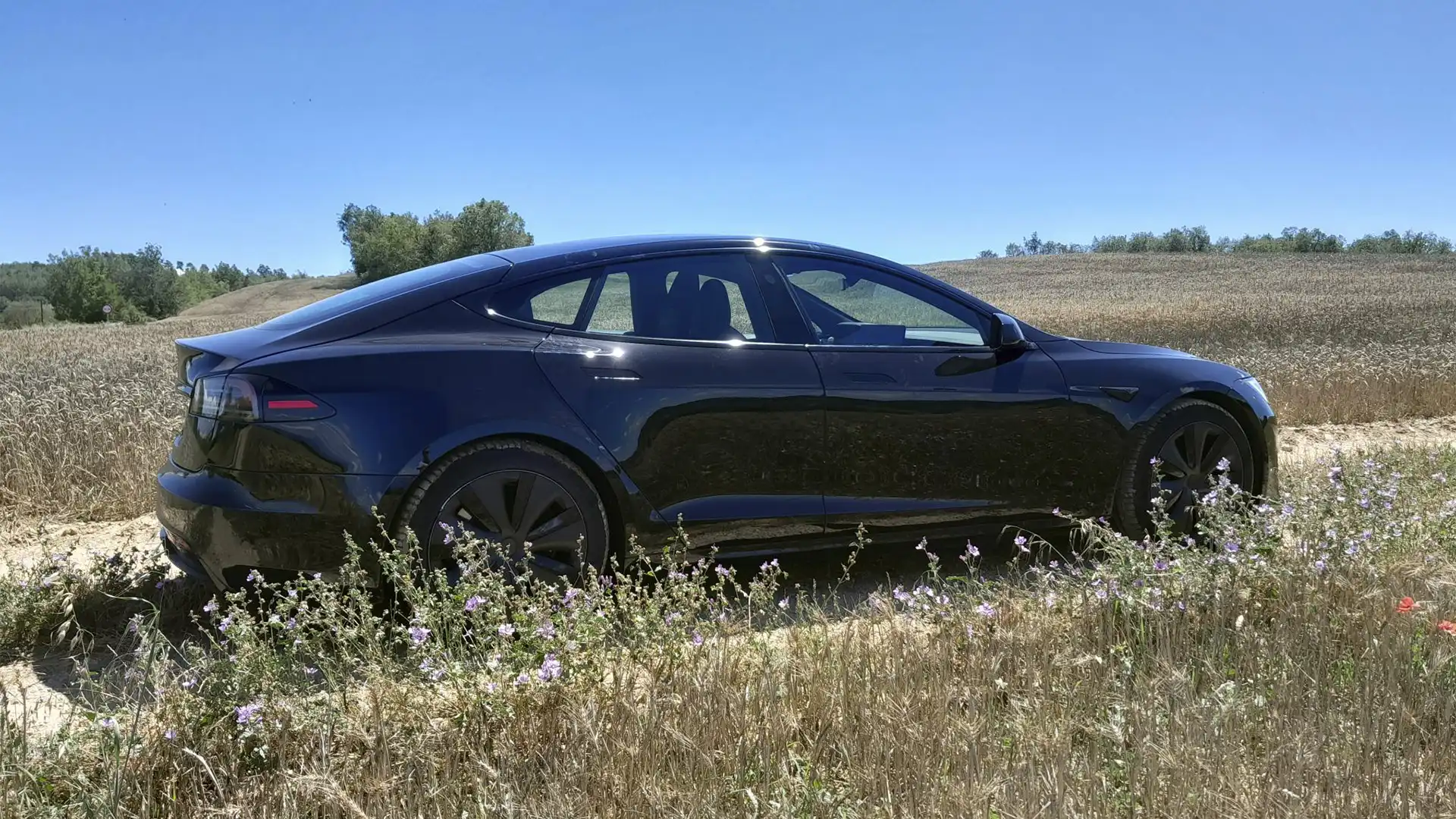 Vehículo eléctrico Tesla Model S en proceso de carga de batería.